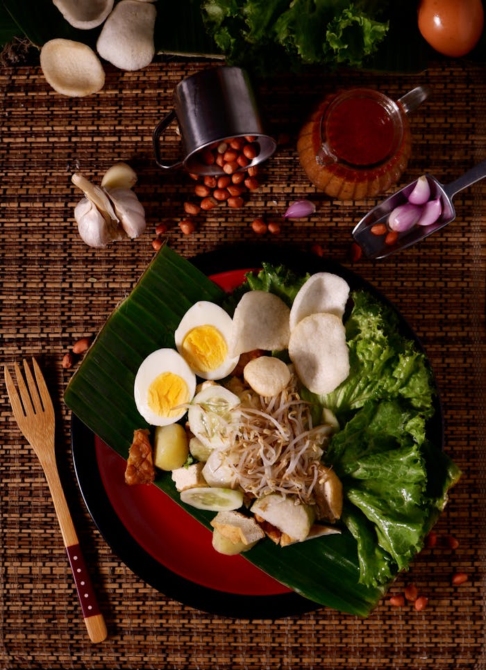 Services Flat lay of traditional Indonesian Gado-Gado salad with peanut sauce and fresh ingredients.