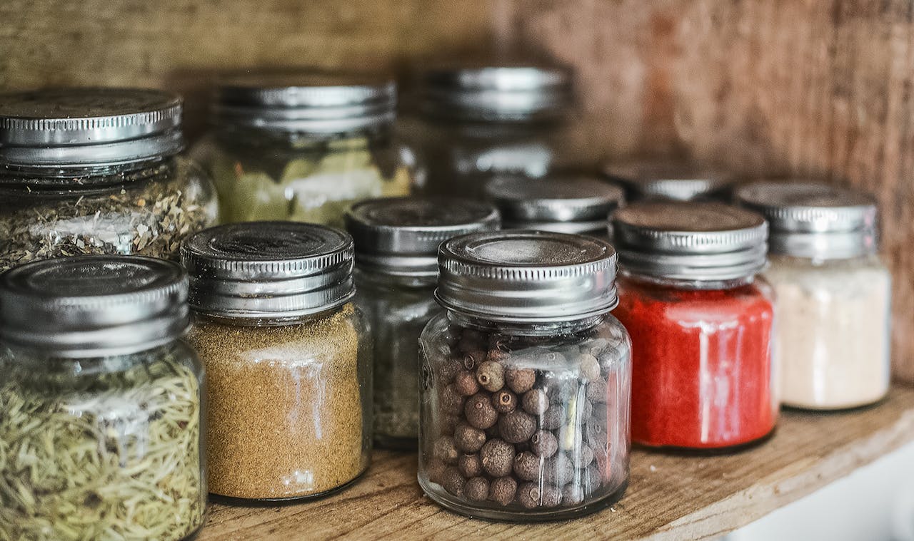 Services Close-up of assorted spice jars with various herbs on a kitchen shelf, showcasing colorful culinary ingredients.